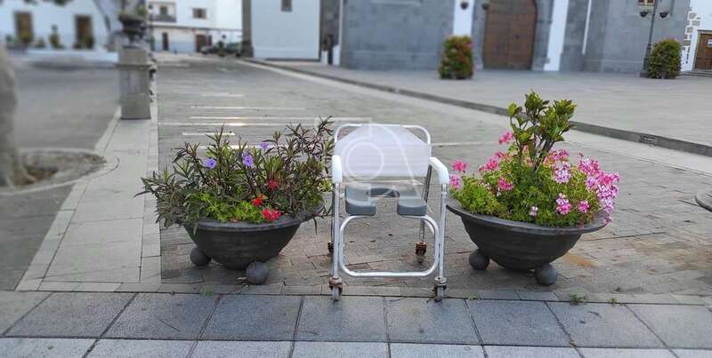 La silla lleva entre dos maceteros desde el pasado viernes, según vecinos del lugar/TA.